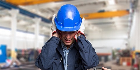 Worker protecting his ears from the noise
