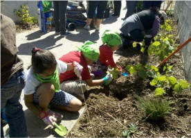 Children plant greenery near a pedestrian bridge in Pacoima.