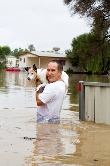 man carrying dog during a flood